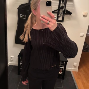 Svart blus - Säljer denna svarta veckade blus från nakd i storlek S. Knytning där bak. Superbra skick. 