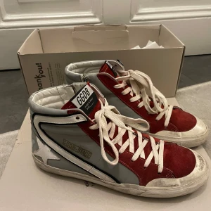 Golden Goose slide - Snygga sneakers från GGDB i rött och grått med vit stjärndetalj på sidan. Skorna har snörning och dragkedja för enkel på- och avtagning. Kom privat för frågor och mer bilder