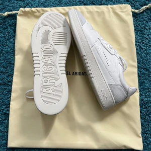 Arigato Dice Lo white  - Snygga vita sneakers från Axel Arigato med stilren design. Finns två sådana par tillgängliga. Storlek 42 på båda. Skick: 9/10 respektive 8,5/10. Pris: 1500kr. Nypris: 2499kr. Vid minsta fundering, tveka inte att skriva!