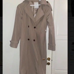 Beige trenchcoat - Beige trenchcoat i storlek xs. Helt oanvänd. Kan skicka fler bilder vid intresse.
