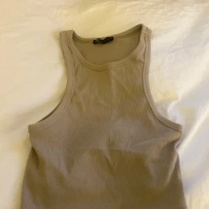 Beige ribbad linnetopp från Zara - Säljer en beige ribbad linnetopp från Zara! Har inte använts många gånger:) Storleken är M men den är ganska liten i storleken så har man S eller till och med XS så hade den passat.