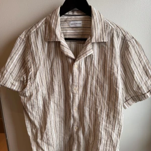 Helt ny Kortärmad Skjorta Från These glory days  - Beige kortärmad skjorta från these glory days. Storlek Small Regular Fit. Helt ny aldrig använd. 