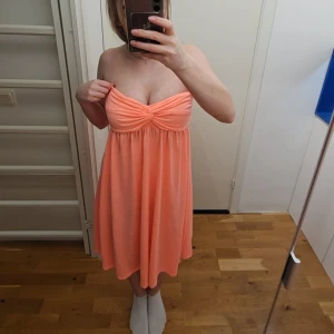 Tubklänning - En korall färgad tubklänning, riktigt somrig i storlek xs/s, perfekt när man är brun. Lätt att klippa av om man skulle vilja korta ned den, gummiresår vid bysten vilket gör så att den inte åker ned! Använd till ett bröllop en gång, normal i storlek 💕🐙