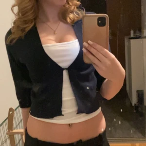 Blå kofta med trekvartsärm - Säljer en stilren svart kofta med trekvartsärm. Perfekt för lager-på-lager och ger en snygg look med sin croppade design. Passar bra till både vardag och festliga tillfällen.