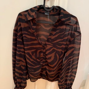 zebramönstrad blus - festlig zebramönstrad blus från gina tricot. brun och svart i ett skirt metarial.