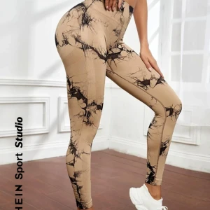 Beige och svarta leggings från SHEIN - Snygga beige leggings med svart abstrakt mönster från SHEIN. Perfekta för träning eller en avslappnad dag. De har en tight passform och är tillverkade i ett stretchigt material för bästa komfort.