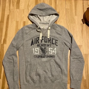 Grå hoodie! - Säljer en grå hoodie från med tryck på framsidan. Tröjan har en klassisk huva och är Perfekt för en avslappnad stil. Skick 7/10