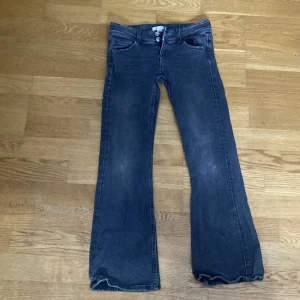 Blå jeansbyxor från Gina Tricot - Säljer ett par klassiska blå jeansbyxor från Gina Tricot. De har en bootcut-stil och är högmidjade med dragkedja och knappar framtill. Perfekta för en avslappnad look. Det är även i bra skick och storlek 146. Orginala priser ligger på 349kr