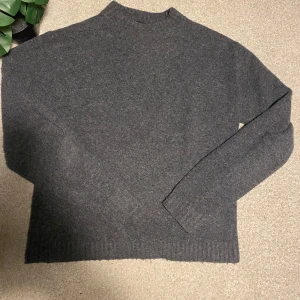 Grå tröja från Uniqlo - Säljer en stilren grå tröja från Uniqlo. Tröjan är i ett mjukt material och har långa ärmar. Perfekt för kyligare dagar. Passar bra till jeans. Priset kan gå ner. Storlek XS men passar även S