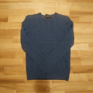 Polo Ralph Lauren Stickad Tröja - Säljer en snygg blå stickad tröja från Polo Ralph Lauren. Perfekt för kyligare dagar. Priset kan diskuteras.