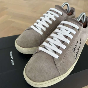Saint Laurent skor - Helt nya saint Laurent skor i modellen trainer court suede Brown. Dom är i väldigt fint skick och aldrig används. Box medföljer. Bara att skriva vid frågor samt intresse. 