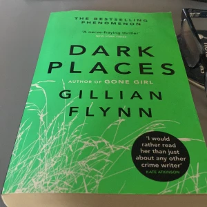 Dark Places storpocket på engelska  - Säljer boken 'Dark Places' av Gillian Flynn, författaren till 'Gone Girl'. En nervkittlande thriller med en grön framsida och citat från kända författare. Perfekt för dig som älskar spänning och mysterier.