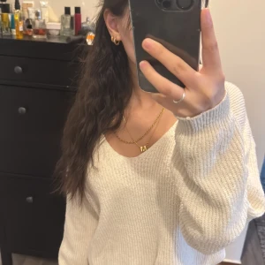 Vit stickad tröja - Säljer en mysig vit stickad tröja med långärmad design. Perfekt för kyligare dagar och enkel att matcha med olika outfits. Tröjan har en avslappnad passform och är superbekväm att bära.