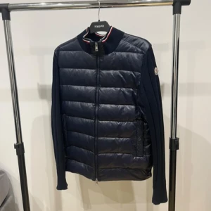 Moncler Cardigan - Helt ny Moncler cardigan, använd 2 gånger bara. 10/10 skick, inga tecken på användning, inga skador eller liknande. Passar perfekt nu inför våren. Det är storlek L och sitter som en L men passar nog även M. Den har även en fungerande NFC tag. Riktigt bekväm och snygg, rekommenderar starkt!