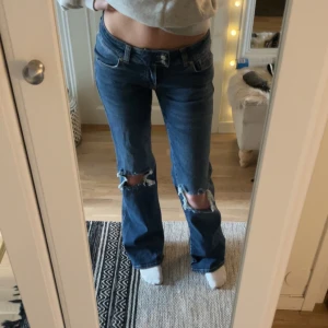 Lowwaist jeans  - Lågmidjade jeans från Lager 157 med hål på knäna och mönster på bakfickorna. Helt nya med prislappen kvar