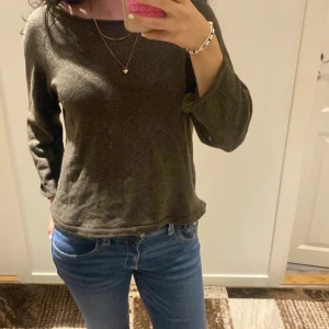 Brun tröja med öppen rygg - Snygg brun tröja med lång ärm och en unik öppen ryggdetalj. Perfekt för en stilren och avslappnad look. Passar bra till jeans eller kjol.