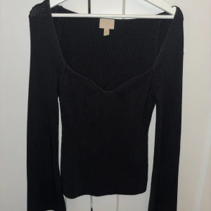 Svart ribbad tröja från H&M - Säljer en snygg svart ribbad tröja från H&M. Den har en v-ringad design och långa ärmar, perfekt för höst och vinter. Tröjan är i fint skick och passar både till vardags och fest.