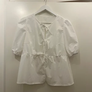 Vit blus - Fin vit blus med knytdetaljer fram. Aldrig använd men prislappen är borttagen.