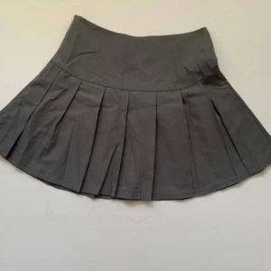 Mini  volangkjol  - Grå kjol i tennis/ volang stil  Tyget är runt men helt defekter och aldrig använt kjolen  Dragkedja vid sidan av kjolen 🎀 Total längd: 40cm  Första partiet till volangerna börjar :15cm  Midjebredd :35 cm