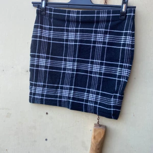 Svart och vit rutig kjol - Säljer en superfin svart och vit rutig kjol. Den är kort och har en klassisk rutig design som passar perfekt för både vardag och fest. Kjolen är i ett mjukt och bekvämt material, perfekt för höst och vinter. Ett måste i garderoben för den som älskar stilrena plagg!