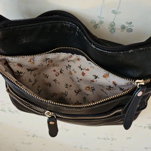 Söt axelväska  - Söt axelväska går justera bandet. Många fack. Lite sliten på sidorna. Hel innuti. Möts i Gbg. 50kr 