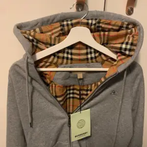 Helt oanvänd mönstrad burberry hoodie med dragkedja. Kvitto och påse slängd men lappar och allt og kvar. Kan gå ner i pris vid snabb affär. Storlek Large men passar M. Hör av er vid minsta fundering eller fråga😊😊