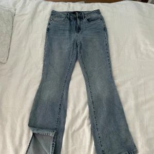 Blå jeans med bootcut - Säljer ett par snygga blå jeans med bootcut och en kort slits nedtill. De är i storlek 29/32.