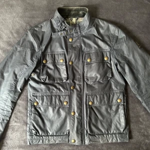 Belstaff Vaxad Jacka - Nice jacka från Belstaff som är storlek 48, passar S/M. Nypris ligger på 6000. Jackan har ett litet hål därav priset (se bild). Kom privat vid funderingar, går alltid att sänka priset vid snabb affär. 