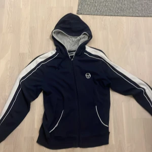 Sergio tacchini hoodie -  Hoodien har några hål på båda sidorna är i storlek L.