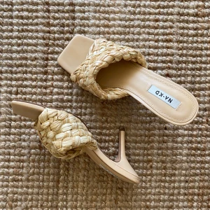 Beige flätade klackar från NA-KD - Säljer ett par beige klackar från NA-KD. De har en flätad design på ovandelen och en elegant klack. Perfekta för sommarens fester, semester eller en stilren vardagslook. Använda men i bra skick.