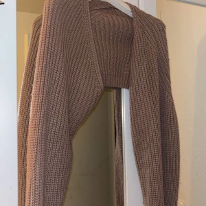 Beige stickad bolero - Snygg beige stickad bolerotopp med ribbad struktur. Använd fåtal gånger fortfarande i bra skick och bekväm.