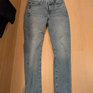 Blå jeans från Dressmann - Säljer ett par klassiska blå jeans från Dressmann. De har en slim passform och är tillverkade i ett slitstarkt denimtyg. Perfekta för en avslappnad stil. Är i nytt skick endast testat och är för små på mig