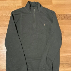 Mörk Grön quarter zip från Ralph Lauren, XL - Säljer en grön quarter zip, oanvänd tröja från Ralp Lauren,  Står ej för postnordslarv eller returer