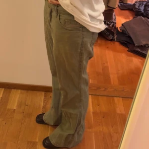 Gröna byxor med bootcut thrifted  - Säljer ett par gröna byxor med bootcut-stil. Perfekta för en avslappnad look. Byxorna är tillverkade i ett mjukt material som ger en bekväm passform.