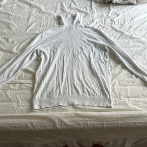 Vit polotröja - Säljer en stilren vit polotröja med långa ärmar. Perfekt för kyligare dagar och enkel att matcha med olika outfits.