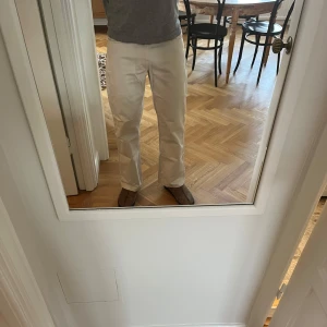 Vita byxor från Eastwest - Snygga vita byxor från Eastwest i bomull och polyester. De har en klassisk design med knappar och dragkedja. Perfekta för en stilren look. Skön passform där byxan landar på skon