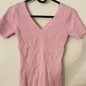 Rosa ribbad topp från MSIS - Säljer en söt rosa ribbad topp från MSIS med v-ringning och korta ärmar. 