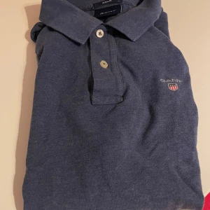 Blå pikétröja från GANT storlek S regular fit - Snygg blå pikétröja från GANT med klassisk krage och knappar framtill. Logga på bröstet. Regular fit, använd 1-2 gånger så nyskick. Ordinarie pris 1000 :- hämtas i Sollentuna eller skickas mot fraktkostnad. 