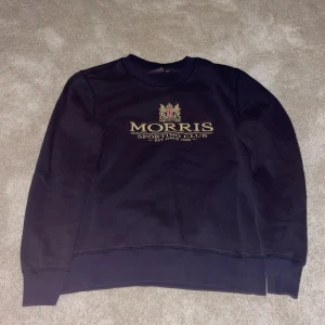 Mörk blå sweatshirt från Morris - Snygg sweatshirt från Morris med tryck på framsidan. Tröjan har klassisk rund halsringning. Perfekt för en avslappnad stil.
