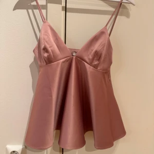 Rosa satinlinne från H&M - Säljer min eleganta rosa linne från H&M med smala axelband. Använd 1 gång🤗