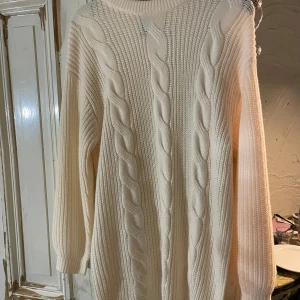 Vit stickad tröja från H&M - Mysig vit stickad tröja från H&M med kabelstickat mönster. Perfekt för kyliga dagar med sin långa ärm och bekväma passform. En klassisk och stilren design som passar till det mesta. 