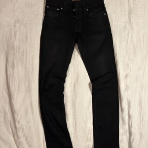 Svarta jeans från Nudie Grim Tim Jeans - Snygga svarta jeans från Nudie Jeans. jeansen är väldigt bra skick är mycket snygga. Storlek 31-34Modell är Grim Tim. nypris på jeansen är 1600