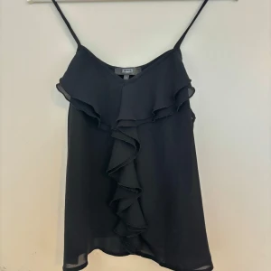 Svart topp med volang - Söt topp med volang detalj som passar perfekt till fest eller liknande, storlek S💕 