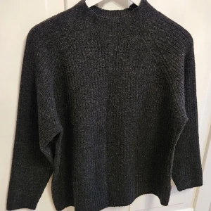 Mörkgrå stickad tröja - Säljer en mörkgrå stickad tröja från Amisu. Köpt ifrån New Yorker 🤍 Tröjan har en ribbad struktur och långa ärmar🤍 perfekt för vintern❄️