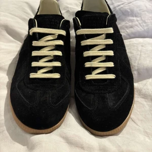 Maison Margiela GATs - Säljer ett par svarta Maison Margiela GATs i storlek 44. Skorna är lätt använda och i mycket gott skick, vilket gör dem till en perfekt julklapp. Originalskopåsar medföljer. Vid en smidig affär kan priset vara förhandlingsbart. Kontakta mig vid intresse!  