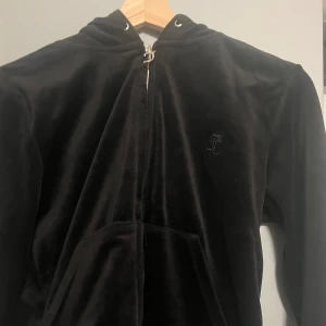 Svart zip hoodie från Juicy Couture - Snygg svart hoodie från Juicy Couture med dragkedja. Hoodien har en huva och är långärmad. Priset kan diskuteras. Storleken är M men den kan även sitta som S 
