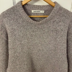 Grå stickad tröja från Carin Wester - Mysig grå stickad tröja från Carin Wester i storlek S. Perfekt för kyliga dagar med sin mjuka och bekväma passform. Tröjan har en rund halsringning och långa ärmar. Finns även i ljusblå!