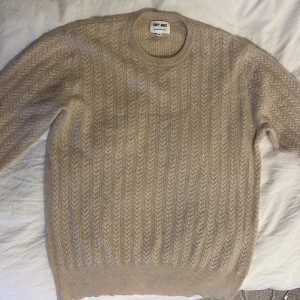 Ljus beige stickad tröja från Soft Goat - Säljer en supermjuk beige stickad tröja från Soft Goat i 100% kashmir. Tröjan har ett snyggt mönster och långa ärmar, perfekt för kyliga dagar. Ett måste i garderoben för den stilmedvetna! Skicket är väldigt bra, säljes i Stockholm 