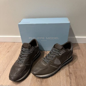  Philippe Model - Snygga grå, bruna sneakers från Philippe Model med snörning och en stilren design. Skorna har en diskret logga på hälen och en bekväm sula som passar perfekt för vardagsbruk.  Knappt andvända, liten storlek för mig. 