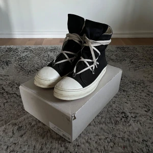 Rick owens penta lace ramones - Rick owens penta lace ramones. Använda men mycket liv kvar i dom. Sulan har lossnat vid en tidpunkt men har lämnats in för att få dom ihoplimmade igen med relativt bra resultat, dom kommer i alla fall inte lossna igen. Högra skon har en liten reva på utsidan men bara estetisk defekt. Säljes i befintligt skick.